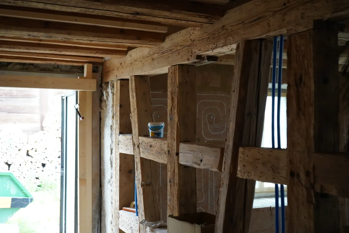 Alte Holzbalken dienen als Stützen für ein altes Bauernhaus.